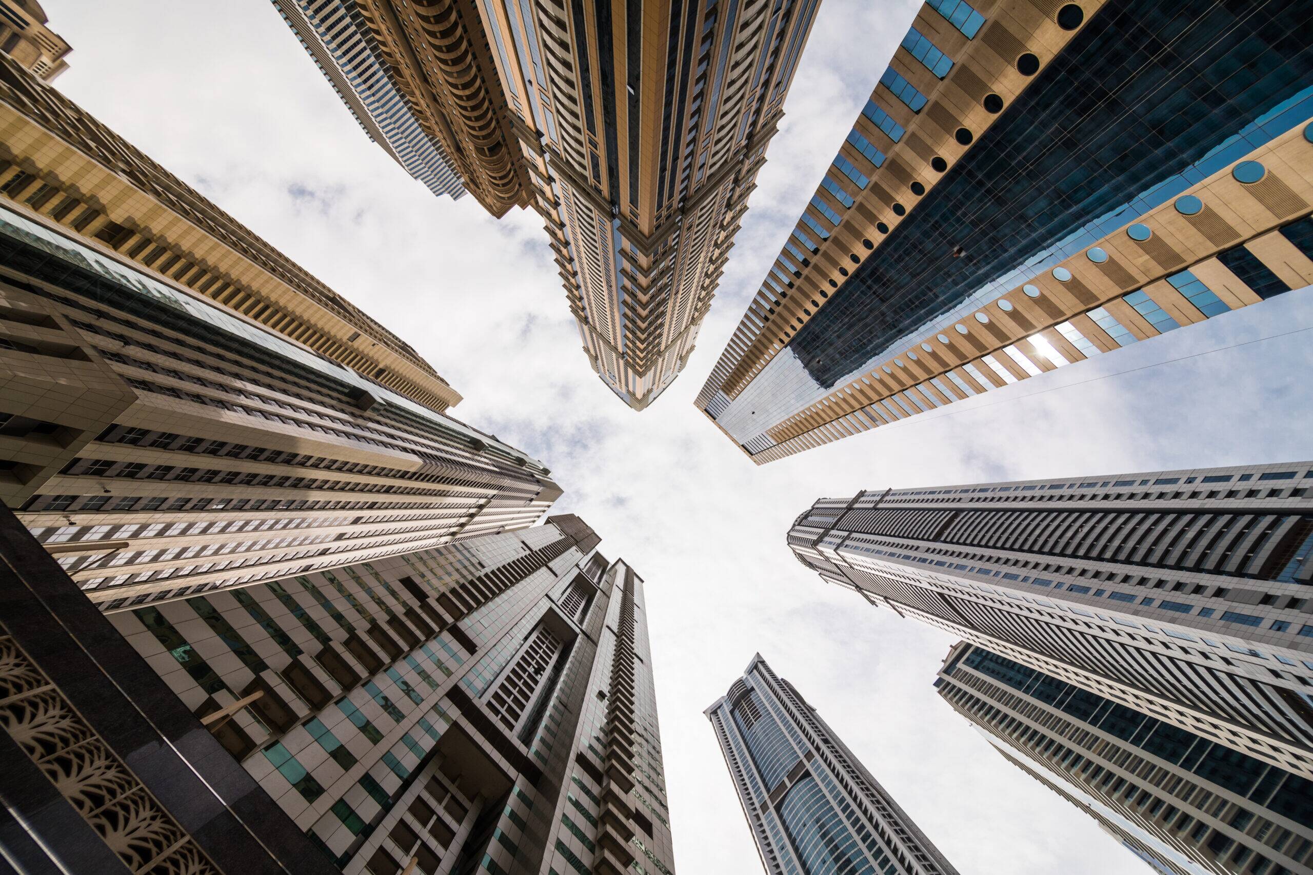 Dramatic perspective with low angle view of skyscrapers looking up to the sky, Dubai. Vanishing point